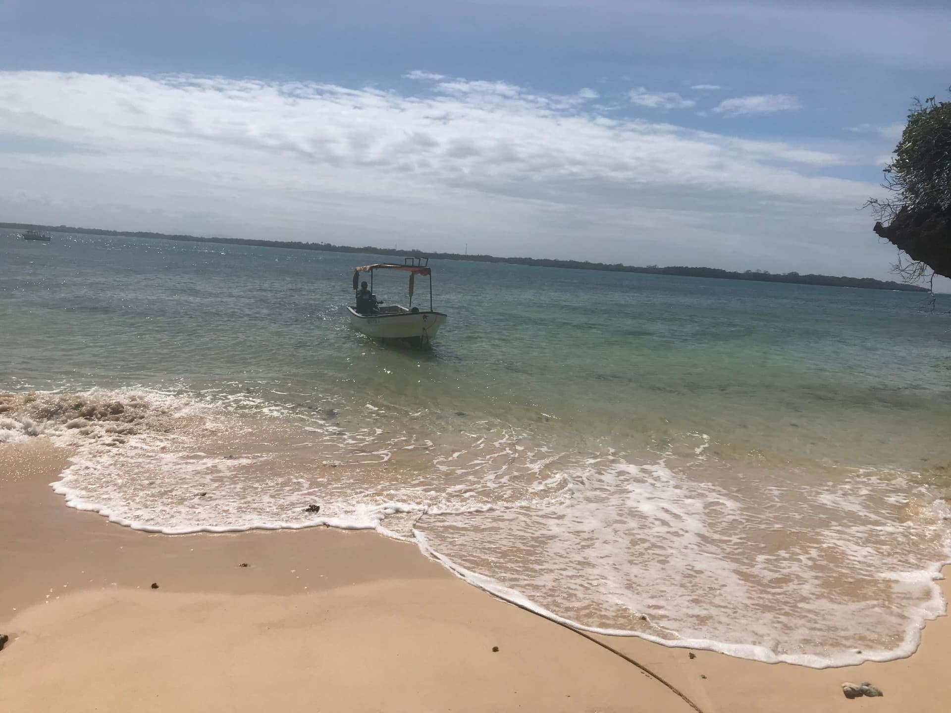 Una piccola barca in acque limpide e basse al largo dell'isola di Wasini
