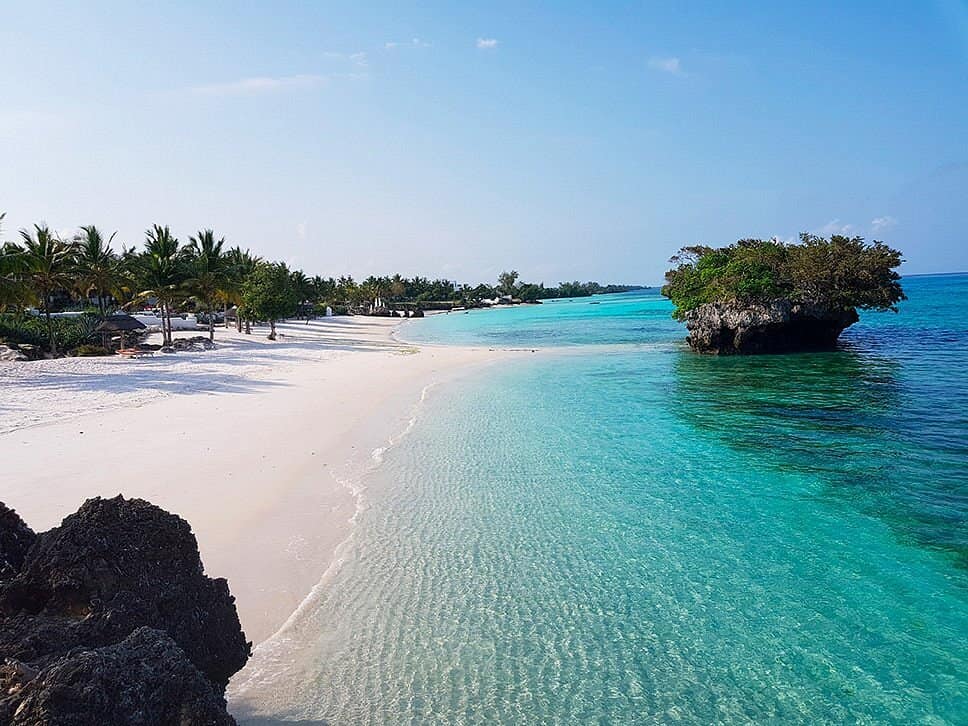 A rock islet just offshore of a white-sand beach on Pemba Island